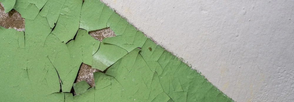 Abblätternde grüne Farbe auf Wand